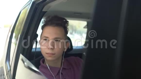 这个十几岁的孩子在车里听音乐视频的预览图
