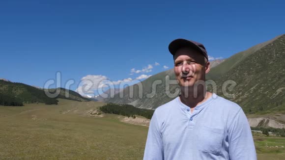 肖像成年男子站在山景和享受新鲜空气视频的预览图