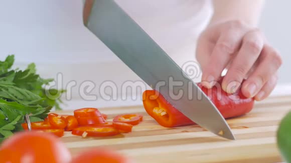 一个女人在厨房里切红辣椒准备一份美味的新鲜蔬菜沙拉作为午餐视频的预览图