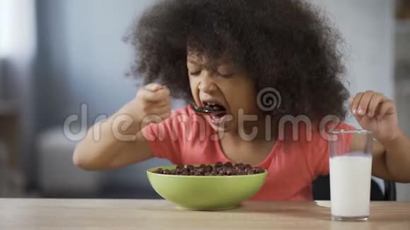 漂亮的非洲裔美国女孩吃玉米片有食欲喝牛奶视频的预览图