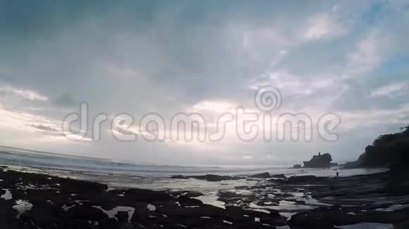 一个女孩正在一部手机上拍摄巴厘岛海洋海岸的美景视频的预览图