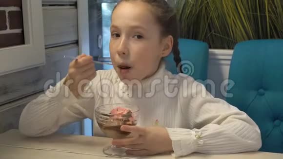 快乐的孩子脸上有雀斑坐在咖啡馆里吃冰淇淋说话特写高细节视频的预览图