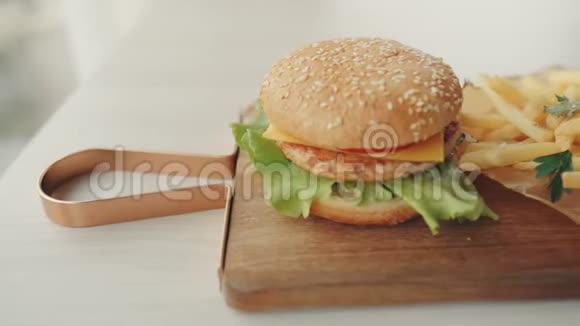 用番茄酱或酱汁把炸薯条用手灌篮桌上放着炸薯条和番茄酱的汉堡快餐视频的预览图