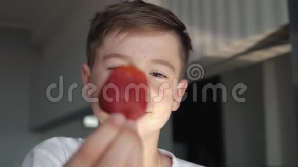 早餐时微笑的男孩吃水果樱桃和草莓视频的预览图