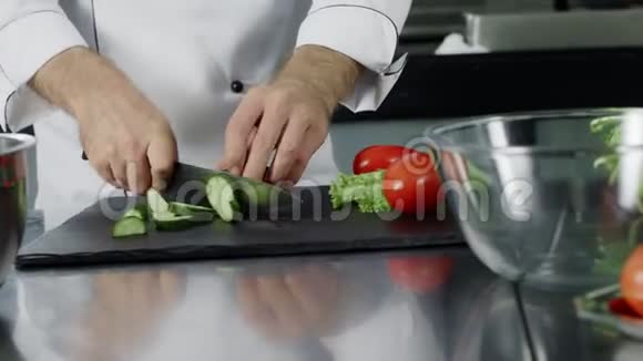 厨师在厨房餐厅切黄瓜厨师手准备新鲜沙拉视频的预览图