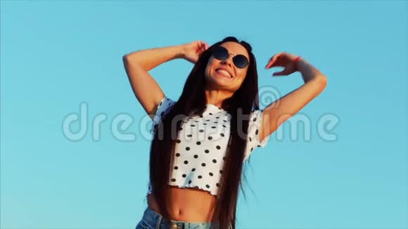 快乐自由的女人在蓝天上高高举起双手看着太阳感觉生活中完全的自由视频的预览图