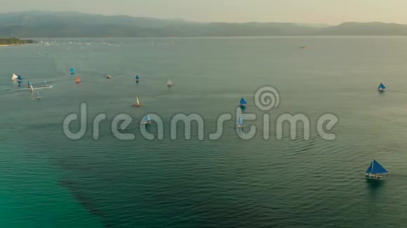 晚上在长滩岛上的蓝色帆船日落时游览的小型帆船视频的预览图