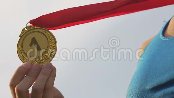 快乐的女运动员亲吻金牌微笑女胜者欢呼胜利视频的预览图