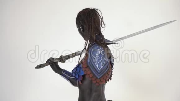 一个有着白色眼睛的黑暗战士把剑举在她的肩膀上转向相机视频的预览图