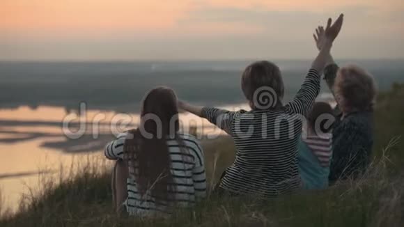 一家人在度假奶奶母女和儿子在山上蚊子在日落时飞视频的预览图