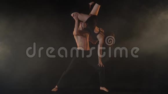 一个男人支撑着一个倒立在他腿上的女人动作缓慢视频的预览图