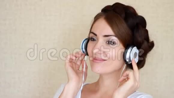 戴着耳机听音乐歌曲的美女在灯光背景下视频的预览图