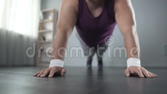 50多岁的胖男人努力做俯卧撑在家训练视频的预览图