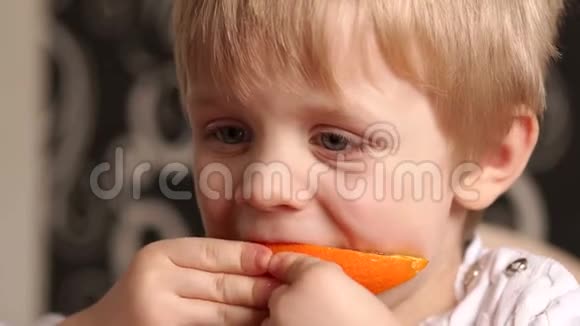 吃多汁熟橙的小男孩的肖像视频的预览图