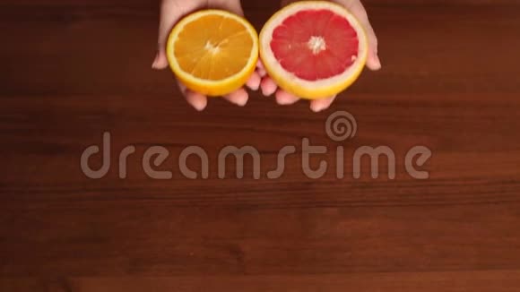 女孩拿着一半的葡萄柚和橘子视频的预览图