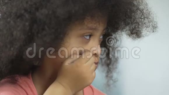 愤怒的非裔美国儿童唐氏综合症坐在桌子旁健康视频的预览图