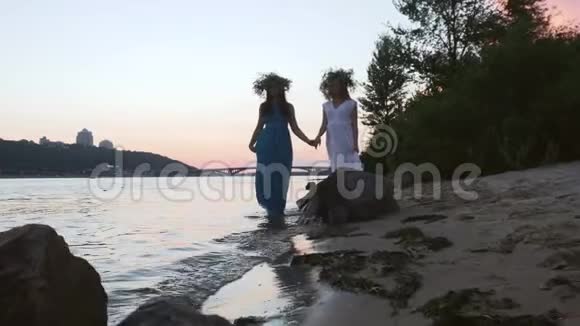两个美丽的女孩沿着河岸散步视频的预览图