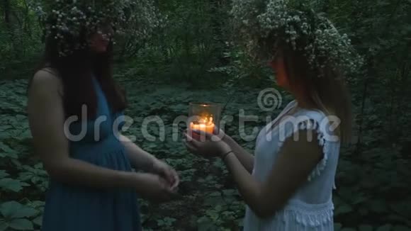 两个小女孩在森林里拿着燃烧的蜡烛视频的预览图