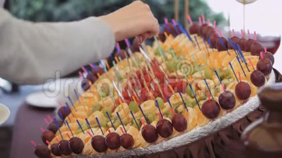 在雨中品尝水果串巧克力火锅喷泉视频的预览图