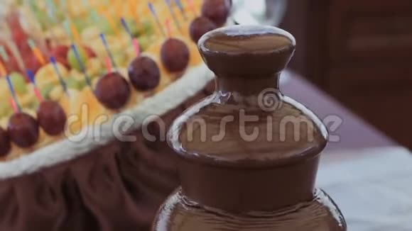 在雨中品尝水果串巧克力火锅喷泉视频的预览图