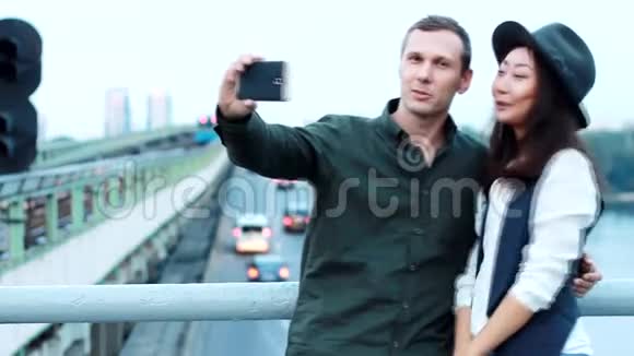 火车附近的桥上的一对夫妇在电话里拍照视频的预览图
