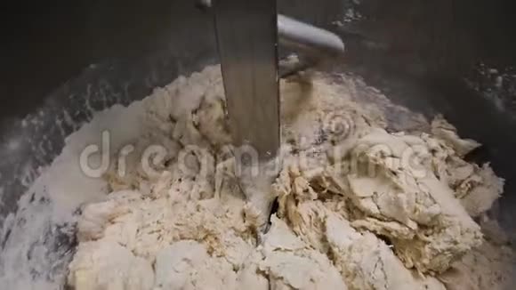 在搅拌机里揉面团的特写镜头库存录像螺旋搅拌机生产糕点设备视频的预览图