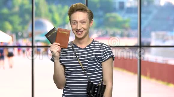 年轻快乐的游客拿着护照视频的预览图