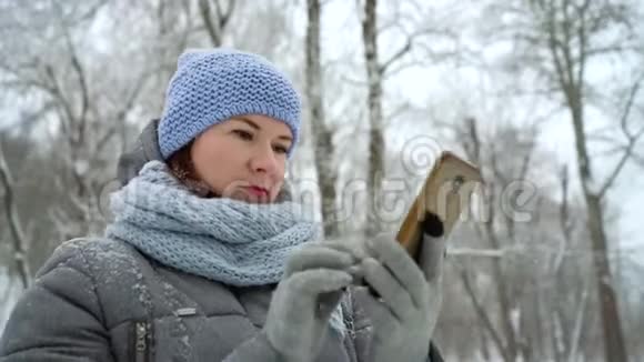 冬季公园的成年女人在打电话视频的预览图