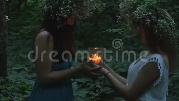 两个小女孩在森林里拿着燃烧的蜡烛视频的预览图