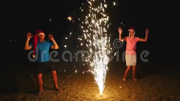年轻男女戴着圣诞帽燃放烟火喷泉闪闪发光视频的预览图
