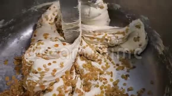 面团在搅拌机中用葡萄干揉捏库存录像用葡萄干揉捏成团的大量面团视频的预览图