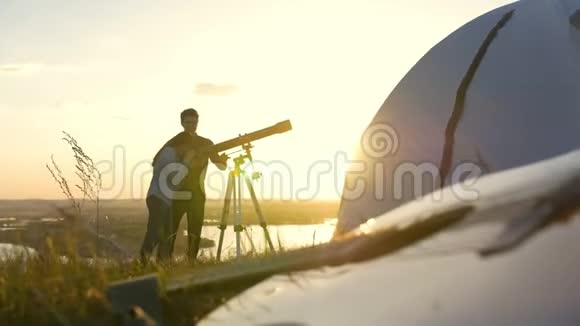 夏天日落时年轻的朋友通过望远镜在山上观看视频的预览图