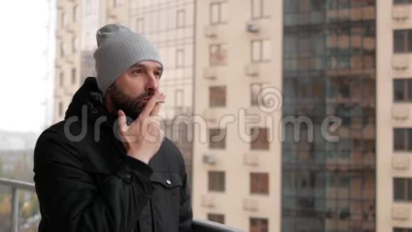 那个留着胡子的家伙站在阳台上抽烟视频的预览图