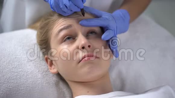 美容师在客户脸上印有深深的前额皱纹视频的预览图