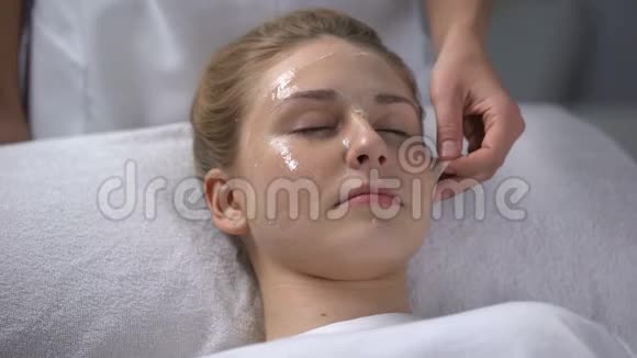 美容师从女孩脸上取出口罩的残留物深层清洁毛孔视频的预览图