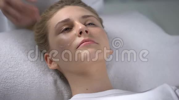 美容师为女性做放松的面部按摩揉搓恢复活力的血清视频的预览图