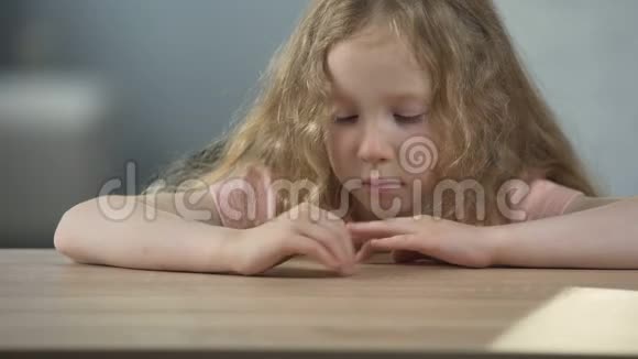 愤怒的长发女孩坐在桌边思考自己的行为视频的预览图