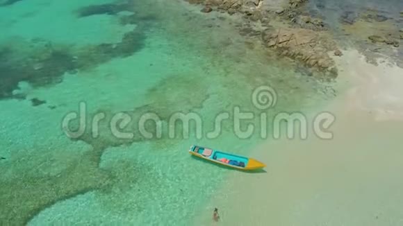 菲律宾一望无际的绿松石蔚蓝的海水和环礁中的女性和小船的鸟瞰图视频的预览图