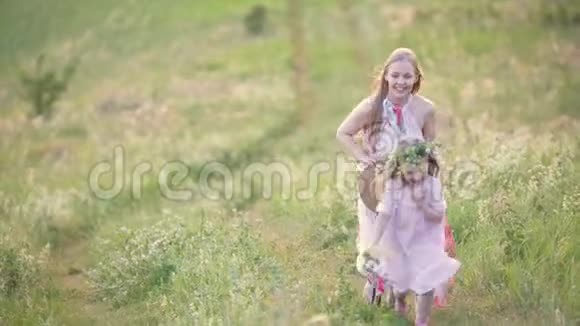 快乐的母女跑过夏天的田野视频的预览图