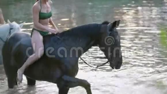 夏天漂亮的女人骑在河里的马上视频的预览图