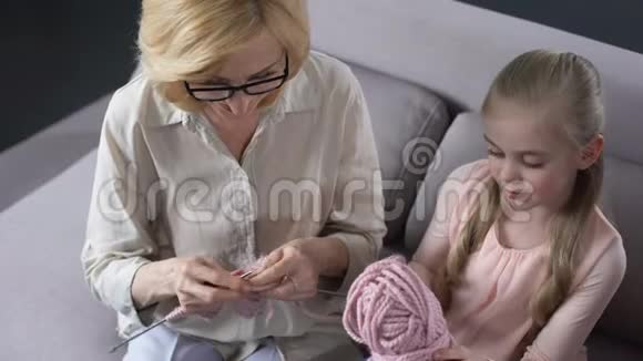金发祖母和她的小孙女在家编织手工制作视频的预览图