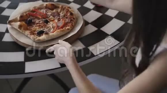 无法辨认的女孩在咖啡馆里旋转披萨的俯视图4K视频的预览图