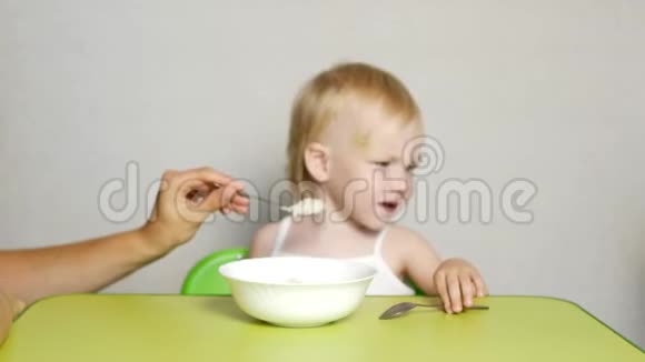 母亲给婴儿喂燕麦片特写儿童营养早餐视频的预览图