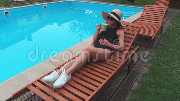 女人在游泳池附近喝咖啡视频的预览图