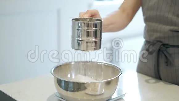 把面粉筛到桌子上的碗里女性将面粉筛到桌子上的一个碗里使面团缓慢运动4K视频的预览图