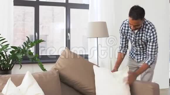 印度男人在家里布置沙发靠垫视频的预览图
