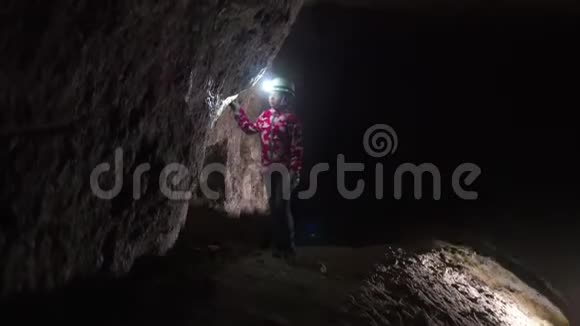 手里拿着灯笼的小女孩在检查洞穴里的矿物质视频的预览图