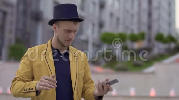 魔术师戴着帽子穿着黄色夹克手里拿着扑克牌视频的预览图