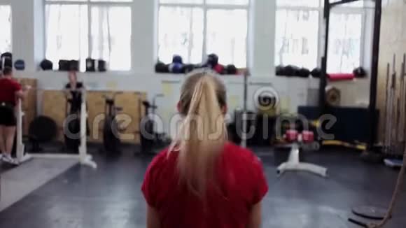 年轻女子运动员用水壶铃进行长周期推在健身房做健身运动的女孩视频的预览图
