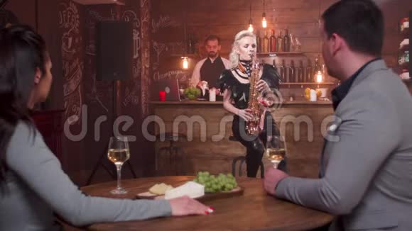 一对年轻男女在约会时听萨克斯管的现场表演视频的预览图